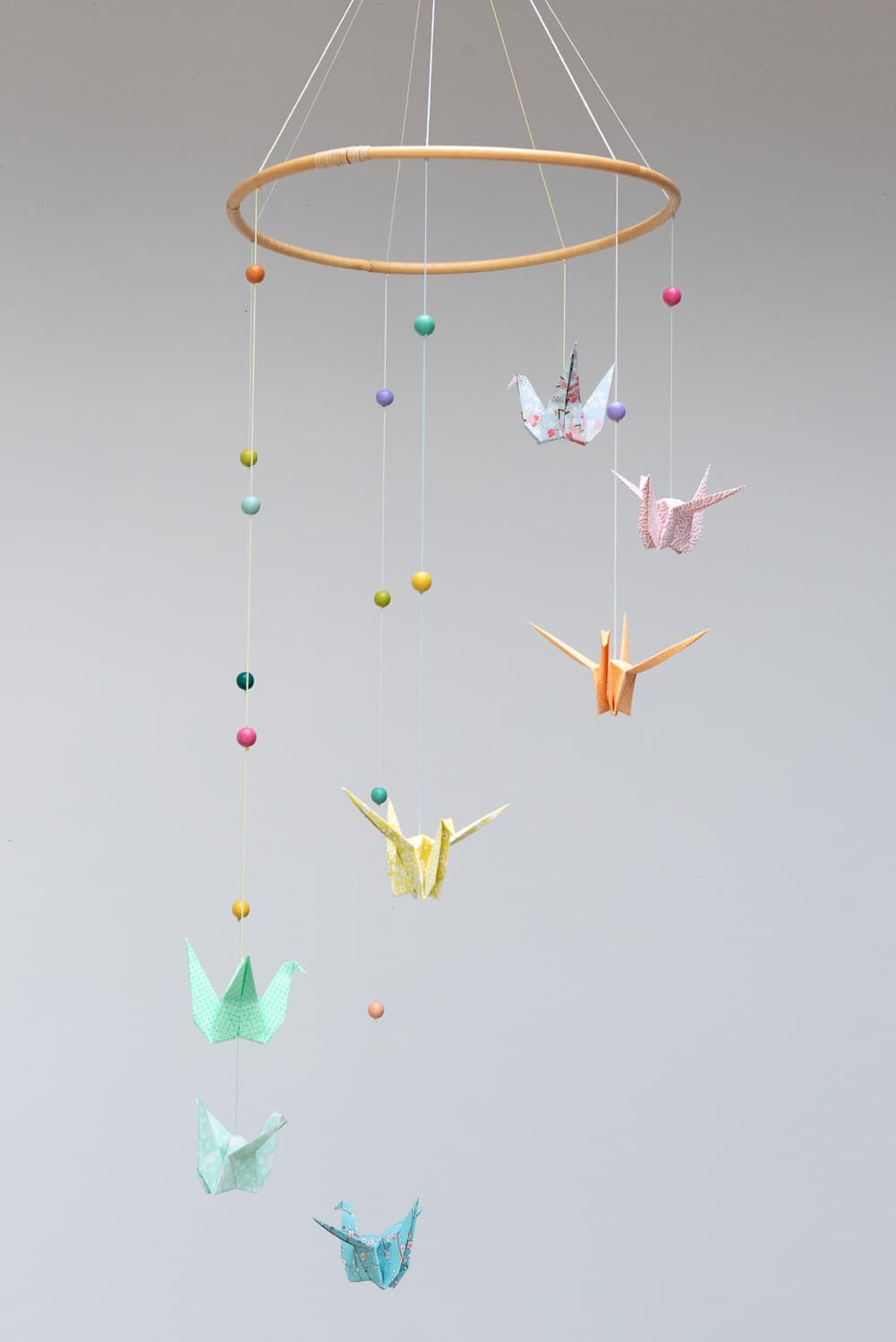 Mobile de grues en origami washi multicolore et perles pastel.