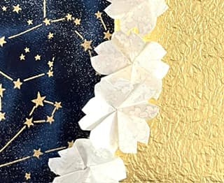 Fleurs en papier blanc bordant un fond doré étoilé